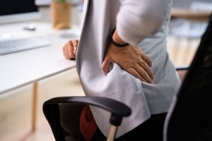 Bolesti zad špatné držení těla žena sedí v kanceláři